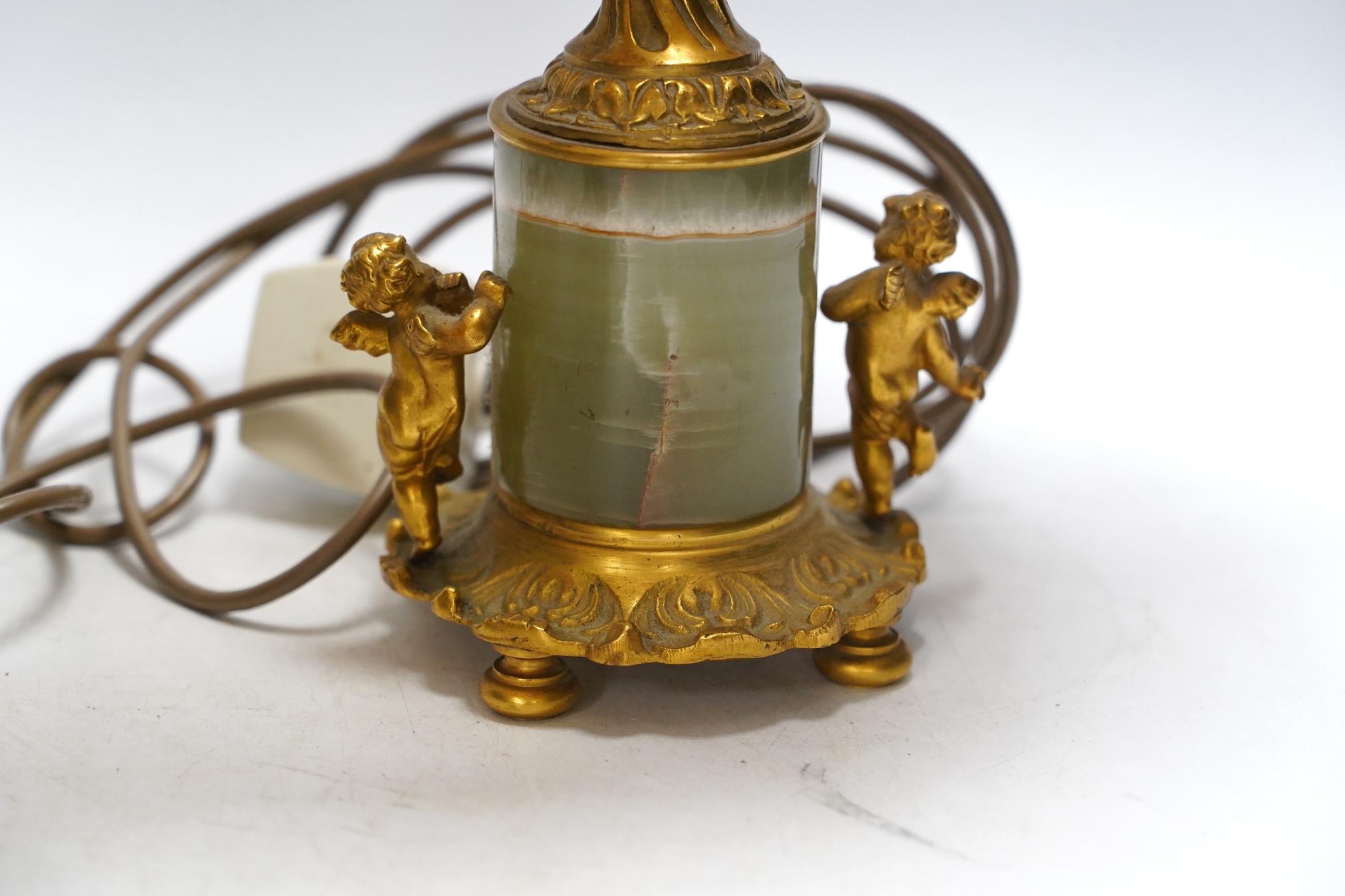 A pair of green onyx and gilt metal mounted cherub table lamps, 40cm high including the shades